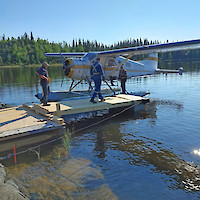 Float plane and dock at Discovery Lake on the Mon Property; left to right, Ralph Tschuncky, Conor Hess, and Steve Jeffries (pilot)